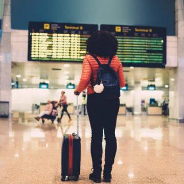 Young Woman At The Airport Checking For The Flight